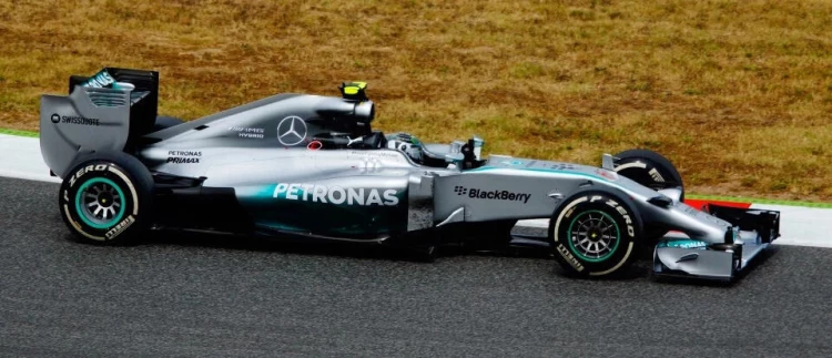 Vista lateral de un auto de Fórmula 1 de Mercedes en una pista de carreras.
